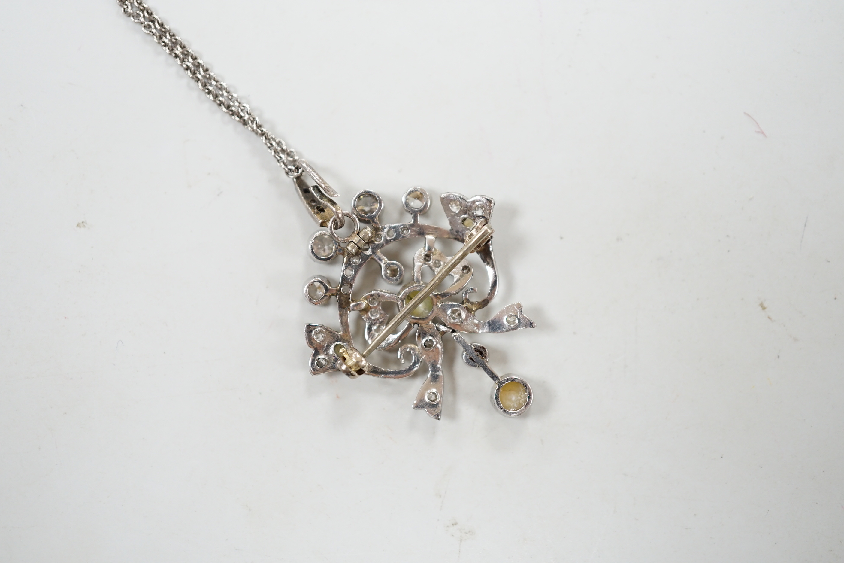 An early 20th century white metal, millegrain set diamond and split pearl cluster set drop pendant/brooch, overall 37mm, gross 5.8 grams, on a later sterling chain.